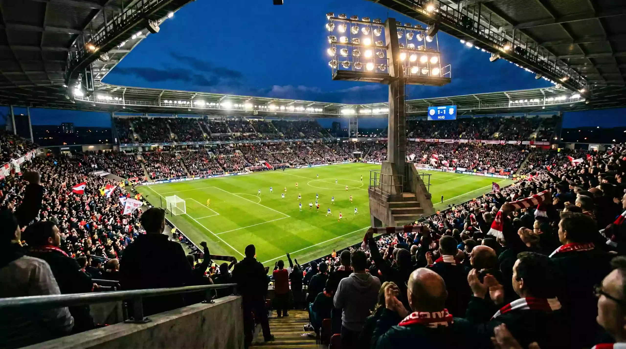 Live Wetten Fußball – Blick auf ein beleuchtetes Fußballstadion bei einem Abendspiel