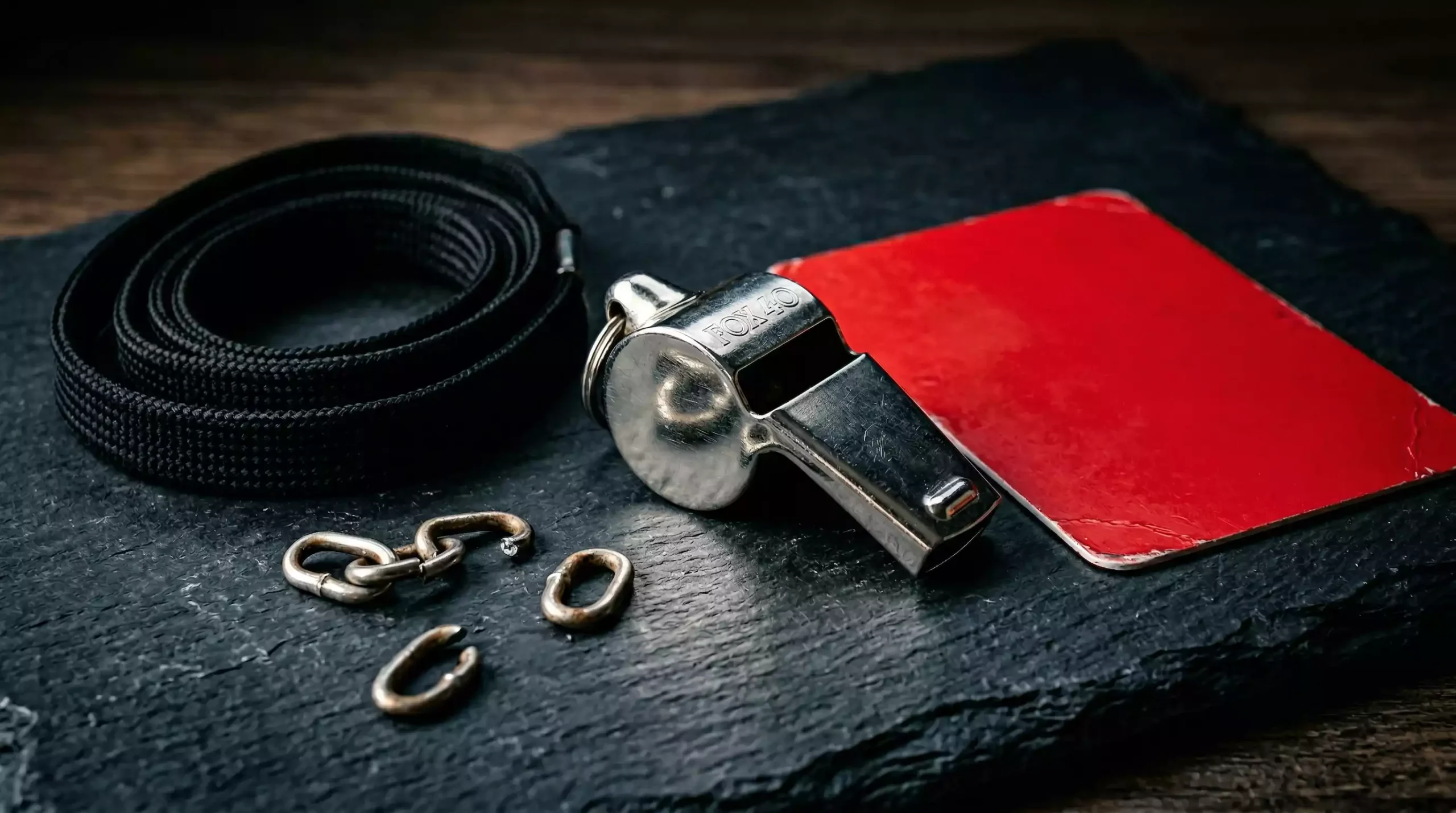 Match-Fixing Fußball – Schiedsrichterpfeife und rote Karte auf einem dunklen Hintergrund