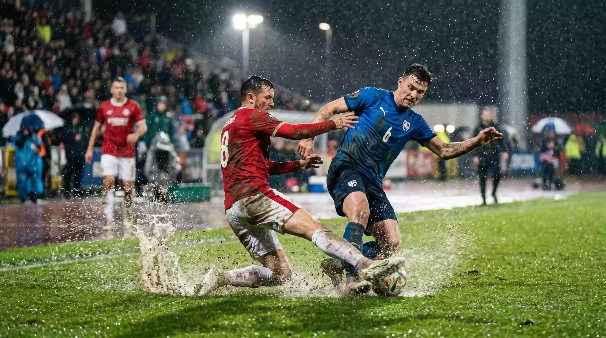 Premier League Wetten – Fußballspieler in Aktion auf einem englischen Rasen bei Regen